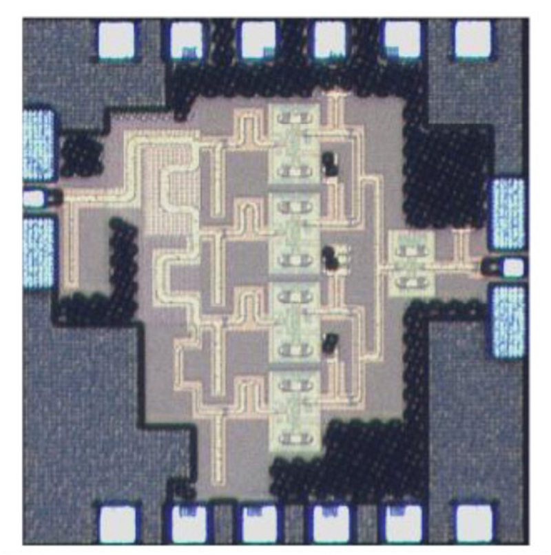 Light gray fabricated core area on a dark gray total die area with gold channels, 6 white squares along the upper and lower edges, and 2 light blue vertical rectangles along the left and right edges. 