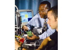 Student and Charles Ume look at devices