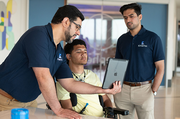 Kinemo team members demonstrating wearable assistive technology with a wheelchair user