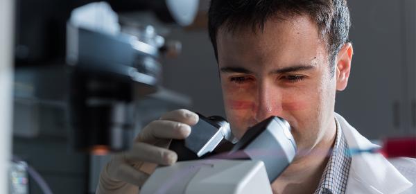 Dr. Fatih Sarioglu looking in a microscope